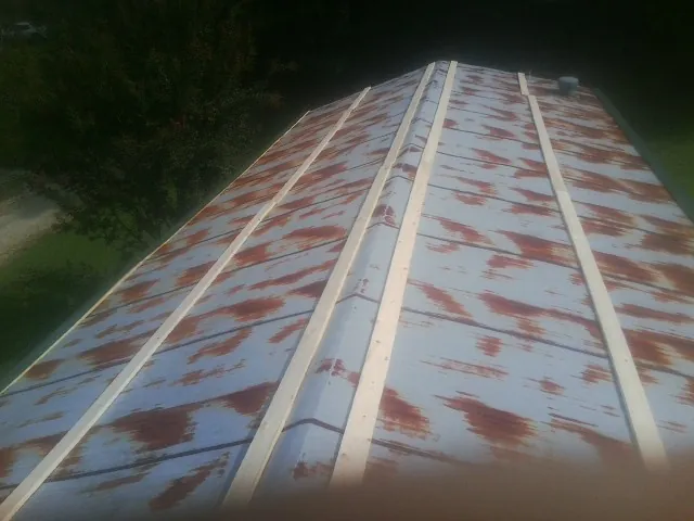 Rusted metal roof panels with new wood purlins before replacement — Storm Damage Roof Repair in Farmingdale by Roofing Brothers