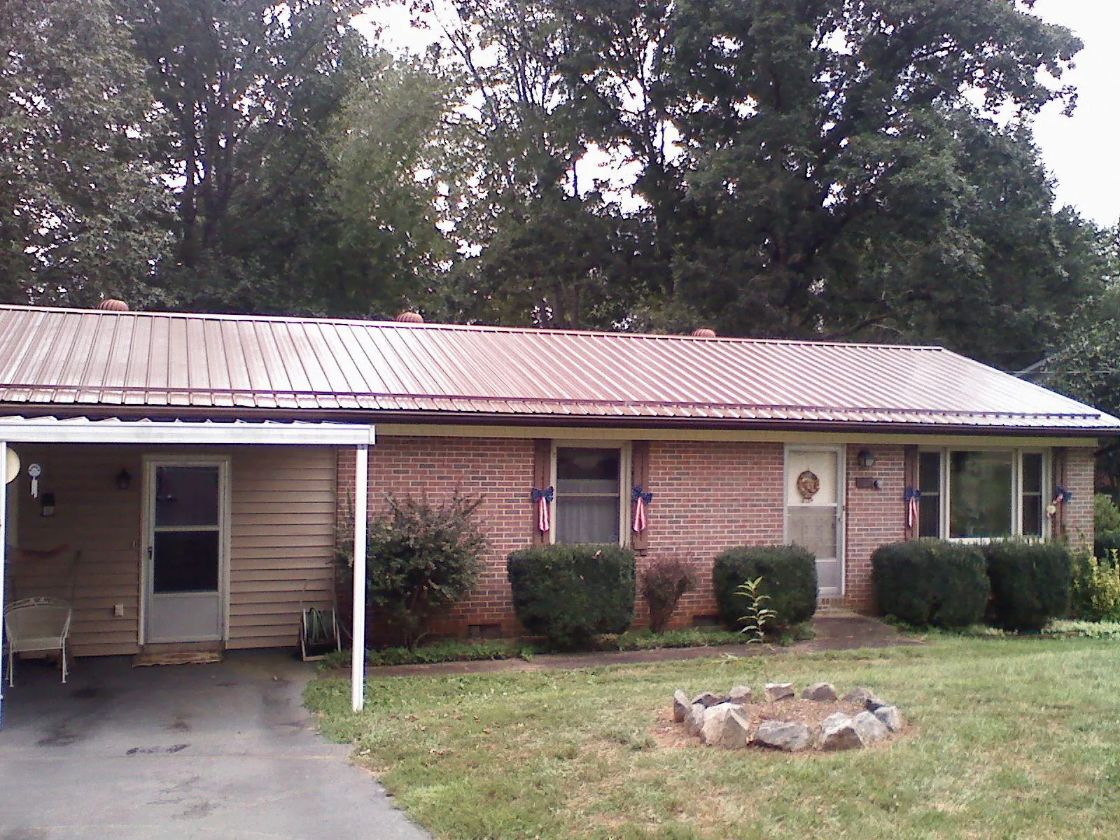 Bronze metal roof and carport on a brick ranch home — Roof Repair work by our crew in Farmingdale